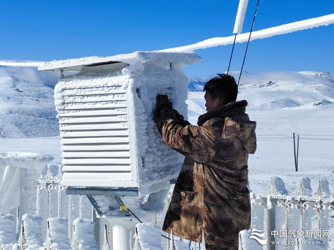 新疆维吾尔自治区和静县,气象工作人员维护结冰的自动气象站百叶箱.